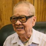 ward-storyteller_jim Jim at his home in Toronto, looking at the Hoi Ping Benevolent Association 20th Anniversary Journal, 2017. Photo Credit: Jennifer Su
