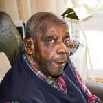 Légende : Le juge Carter qui regarde sa photo de classe de Hester How chez lui à Etobicoke, 2017. Crédit photo : Kathy Grant